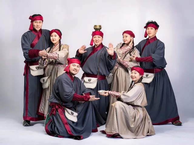 Dance ensemble in traditional grey and burgundy costumes